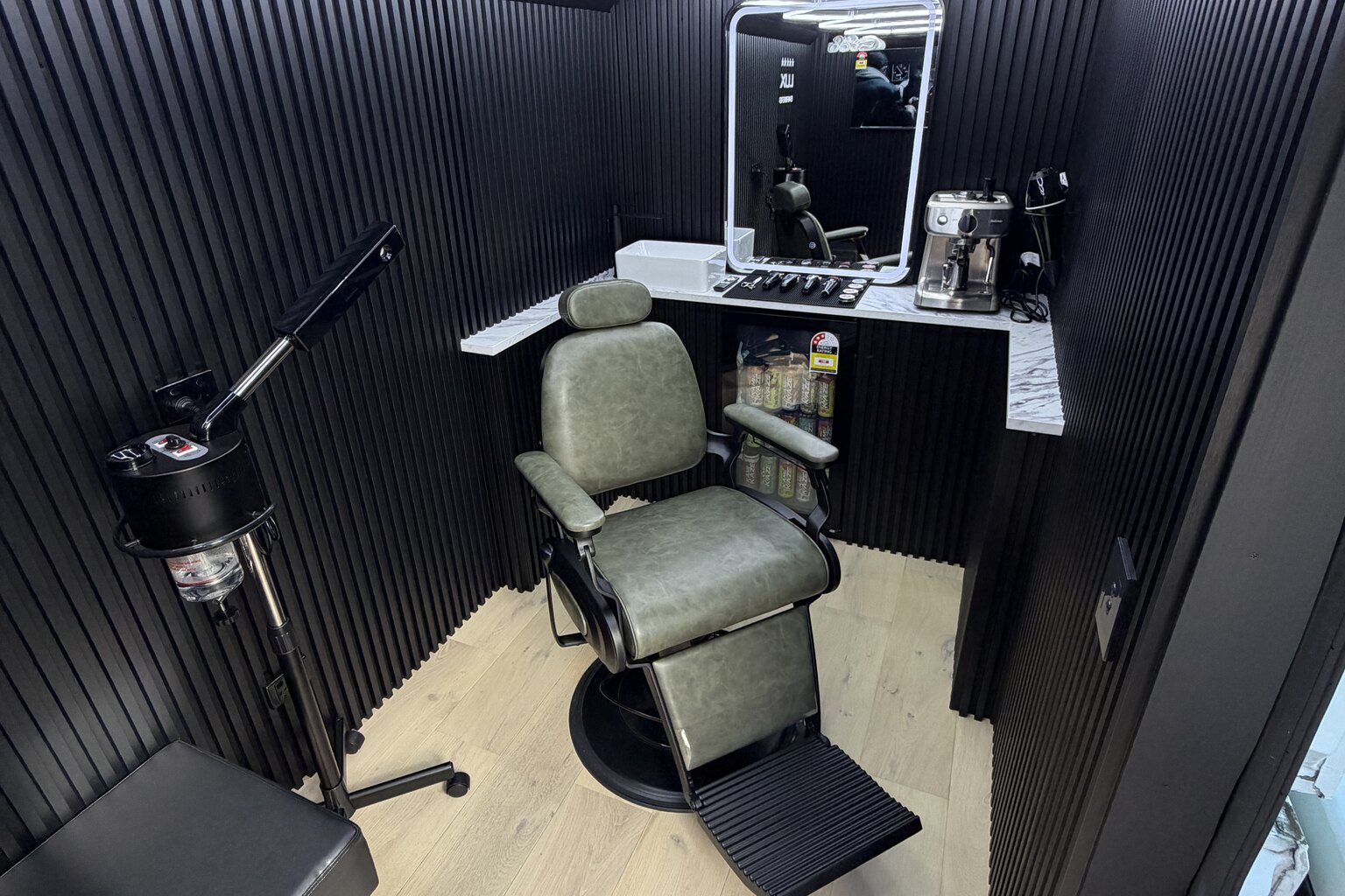 A client seated alone in the barber chair inside the Lux Barbers luxury mobile studio