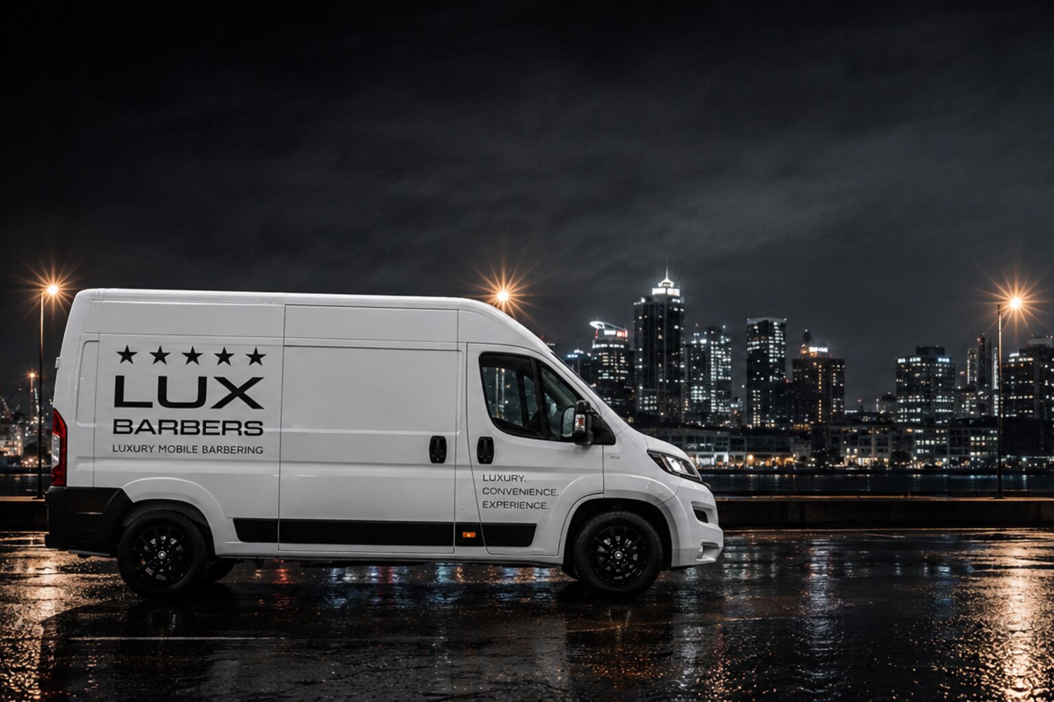 The Lux Barbers van on a wet city street at night with the Auckland skyline and Sky Tower behind